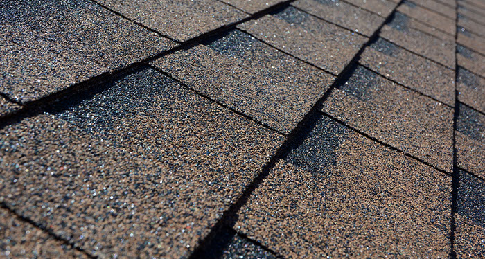 Roofing shingles reinforced with a fiberglass mat