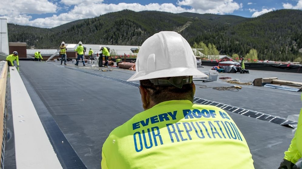 Commercial roofer installing EPDM membrane