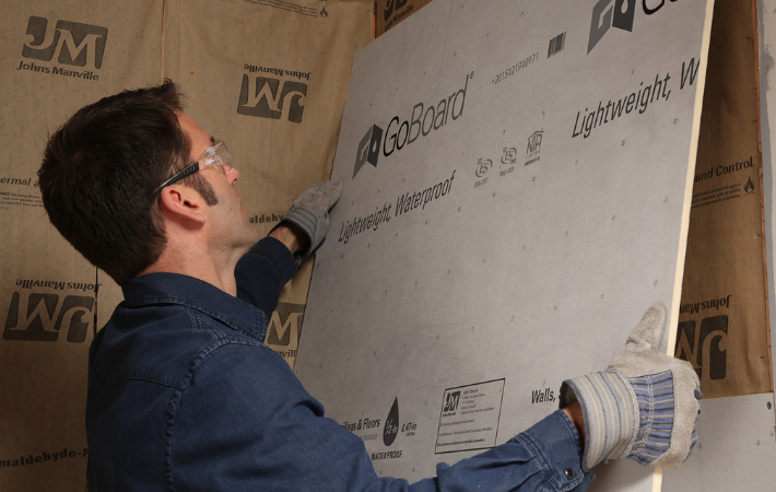 Person installing GoBoard Tilebacker on wall
