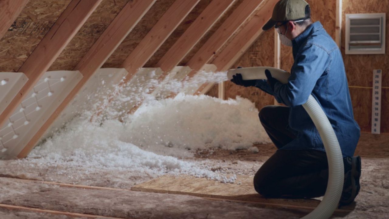 Contractor installing blowing wool insulation
